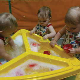 Children playing with water activities at Caego Day Nursery