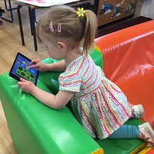 Child using iPad in nursery