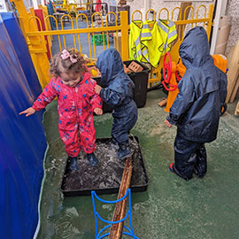 Nursery children playing with sand pit